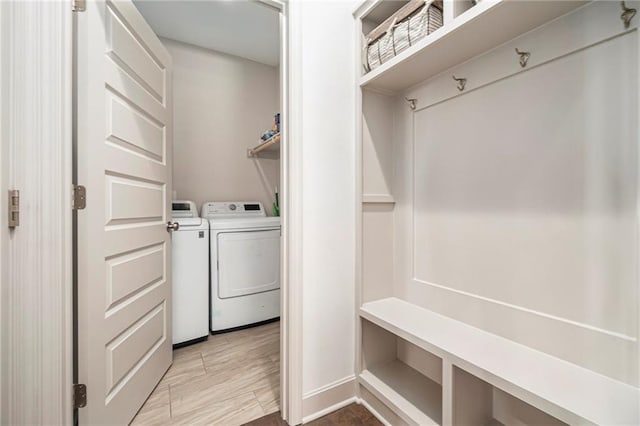 mudroom featuring light wood-style flooring and washing machine and clothes dryer