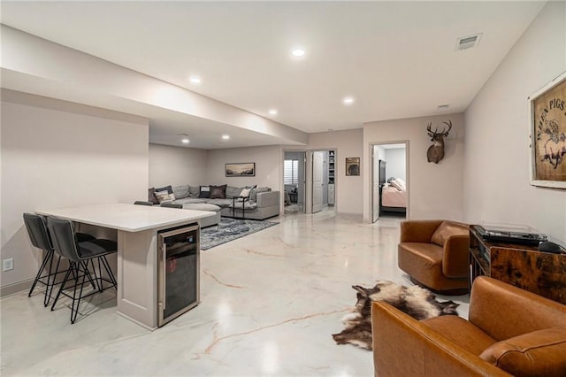 kitchen featuring visible vents, wine cooler, a breakfast bar, and open floor plan