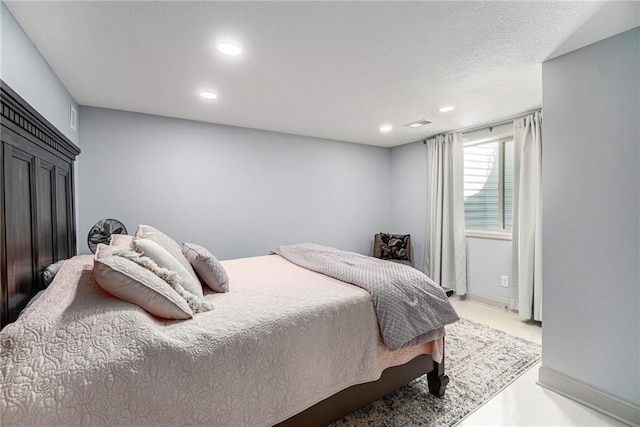 bedroom with visible vents, recessed lighting, a textured ceiling, and baseboards