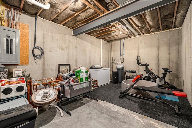 unfinished basement featuring electric panel and fridge