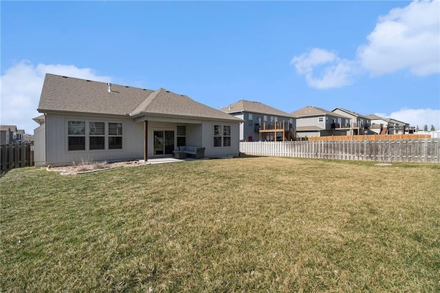 rear view of house featuring a patio, a yard, and a fenced backyard