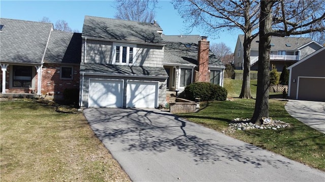 split level home with an attached garage, a chimney, concrete driveway, a front lawn, and brick siding