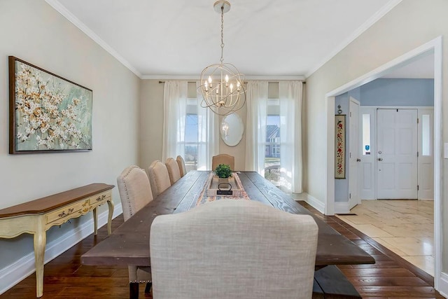 dining room featuring a chandelier, hardwood / wood-style flooring, baseboards, and ornamental molding