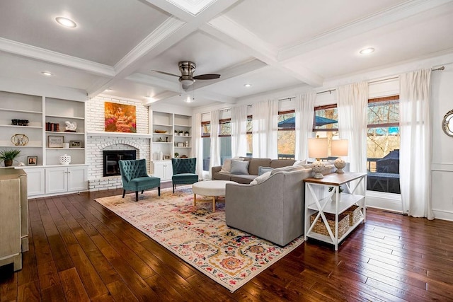 living room featuring beam ceiling, dark wood-type flooring, a fireplace, and coffered ceiling