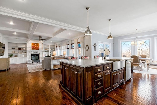 kitchen featuring a sink, dark wood-type flooring, an island with sink, and coffered ceiling