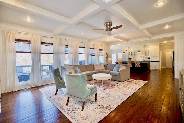 living room with beam ceiling, coffered ceiling, dark wood-style floors, and a ceiling fan