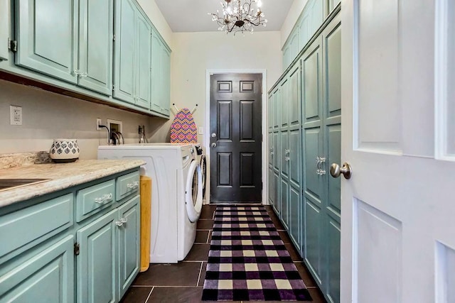 laundry area featuring an inviting chandelier, dark tile patterned flooring, cabinet space, and washer and clothes dryer