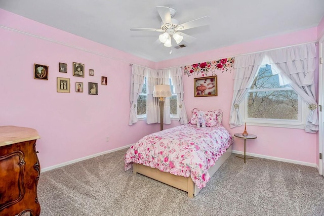 carpeted bedroom featuring a ceiling fan, visible vents, and baseboards