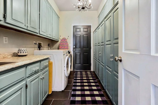 laundry room featuring an inviting chandelier, cabinet space, independent washer and dryer, and dark tile patterned flooring