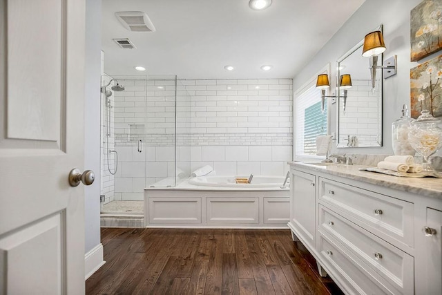 bathroom featuring a garden tub, visible vents, a shower stall, wood finished floors, and vanity