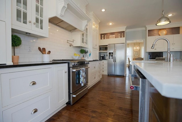 kitchen featuring white cabinetry, appliances with stainless steel finishes, pendant lighting, and custom range hood