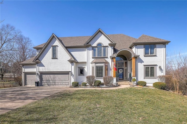 view of front of home with stucco siding, a front yard, an attached garage, and driveway