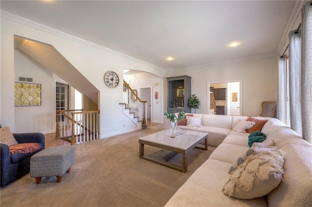 carpeted living area with visible vents, baseboards, recessed lighting, arched walkways, and crown molding