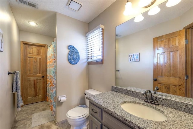 bathroom with visible vents, baseboards, toilet, vanity, and a textured ceiling