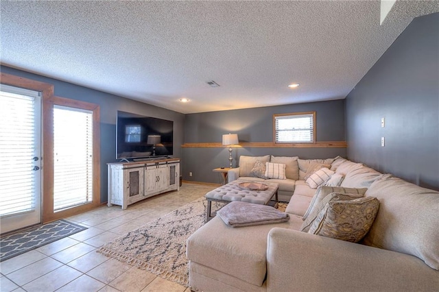 living area with light tile patterned floors, recessed lighting, visible vents, and a textured ceiling