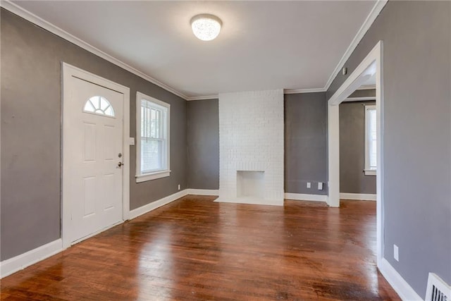 foyer with visible vents, a healthy amount of sunlight, wood finished floors, and crown molding