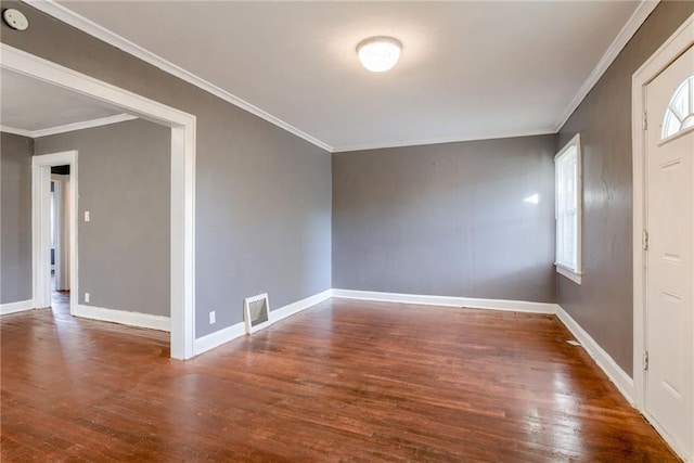 foyer entrance featuring visible vents, crown molding, baseboards, and wood finished floors