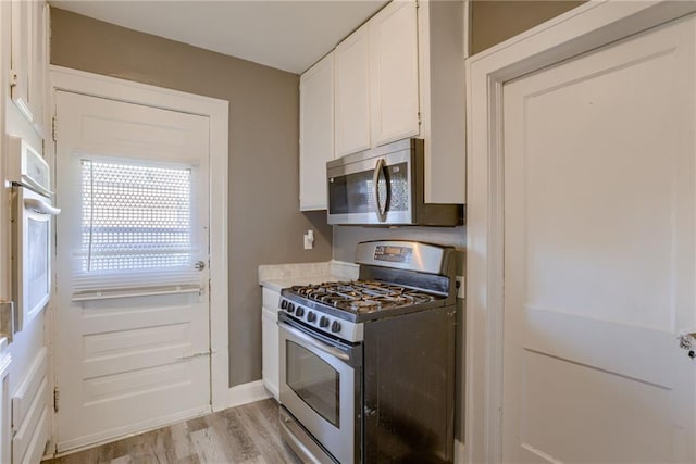 kitchen featuring light countertops, white cabinets, light wood-style floors, and stainless steel appliances