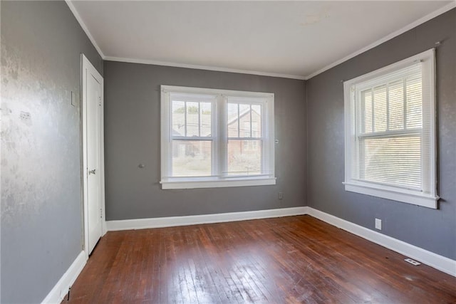 spare room featuring hardwood / wood-style flooring, baseboards, and ornamental molding