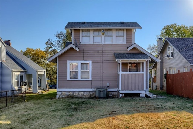 rear view of property with a lawn and fence