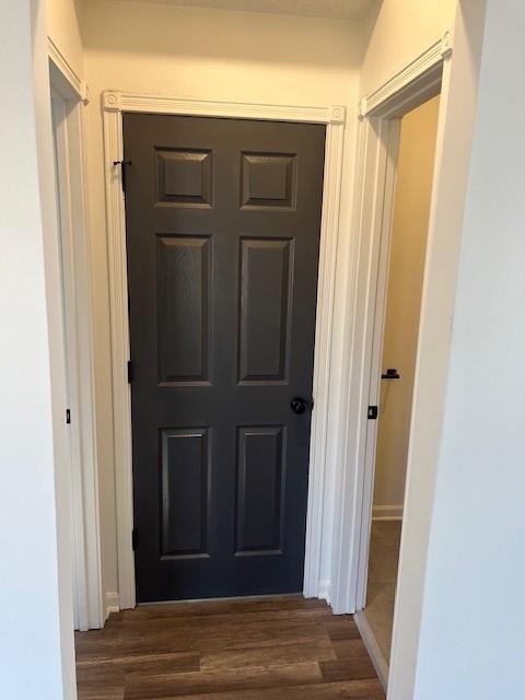 hallway featuring baseboards and wood finished floors