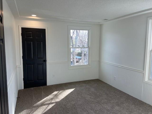 interior space featuring a wainscoted wall and a textured ceiling