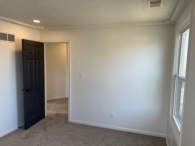 unfurnished room with baseboards, visible vents, and carpet floors