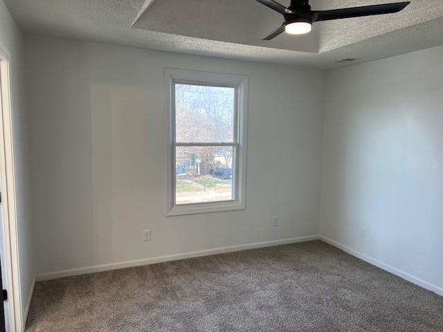 unfurnished room featuring carpet flooring, a textured ceiling, and baseboards