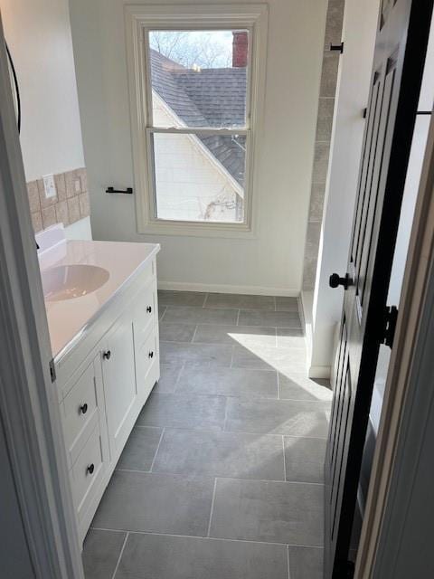 bathroom with a healthy amount of sunlight, vanity, and baseboards