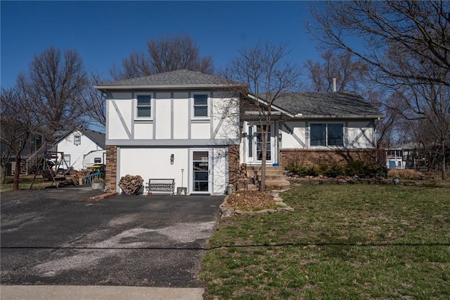 view of front of home featuring stucco siding, brick siding, and a front lawn