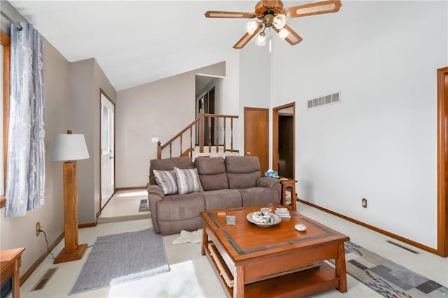 living room with stairs, visible vents, and a ceiling fan