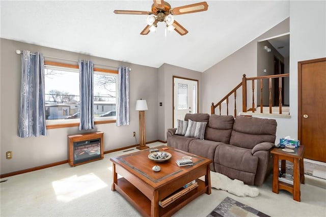 living area with stairway, carpet flooring, baseboards, ceiling fan, and vaulted ceiling