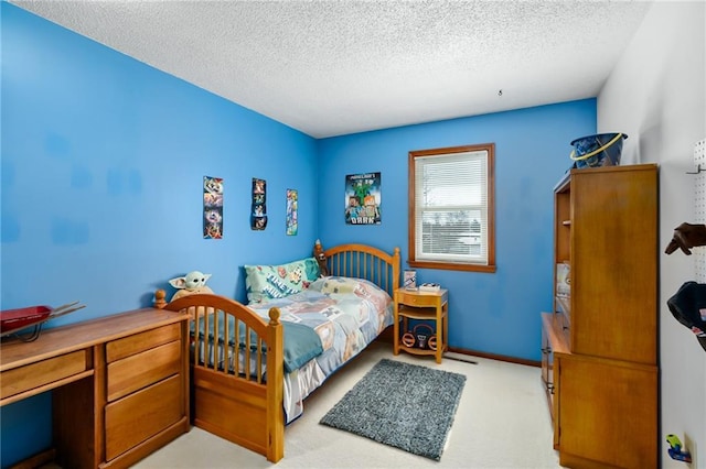 bedroom with a textured ceiling, baseboards, and light carpet