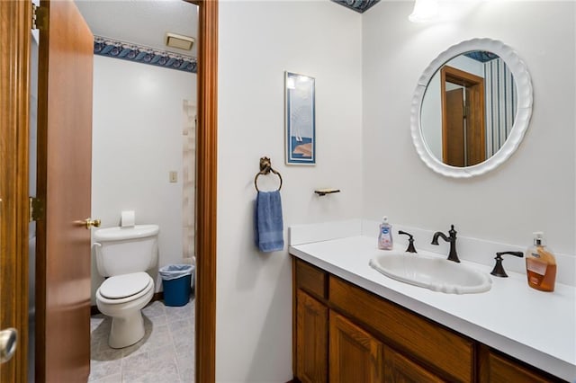 bathroom featuring vanity, tile patterned floors, and toilet