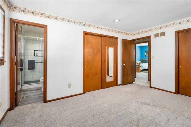 unfurnished bedroom featuring visible vents, baseboards, carpet, and a textured ceiling