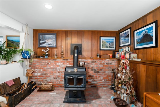 living room featuring a wood stove and wood walls