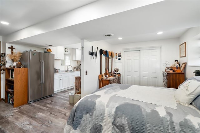 bedroom featuring wood finished floors, recessed lighting, a sink, a closet, and high quality fridge