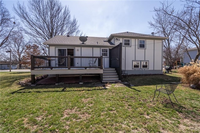 rear view of property featuring a lawn and a deck