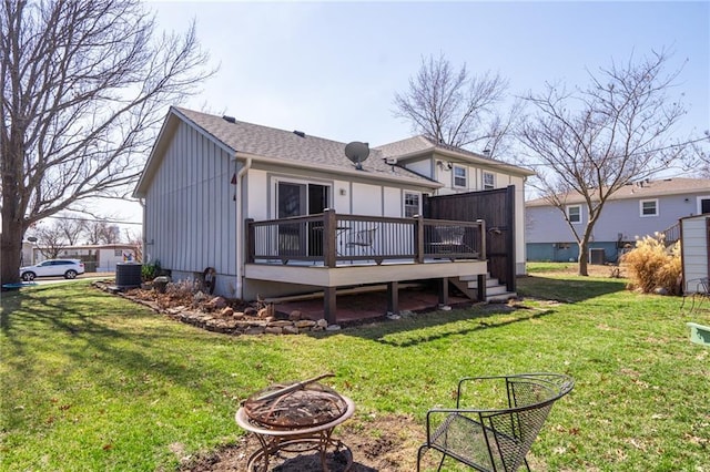 back of house featuring a yard, a fire pit, and a deck