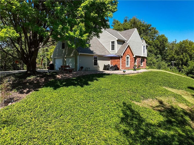 view of front of property featuring a front yard, a garage, and brick siding