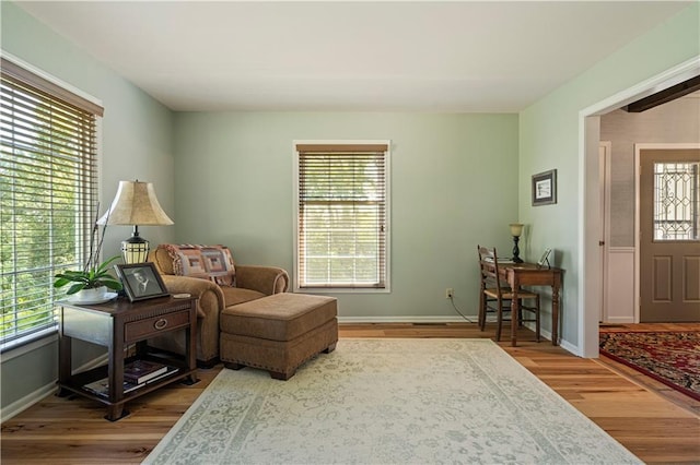 living area with baseboards and wood finished floors