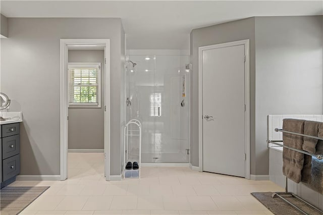 bathroom featuring vanity, baseboards, and a stall shower