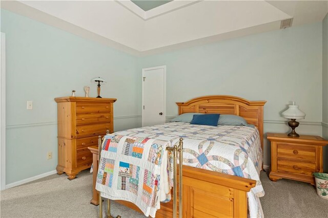 bedroom featuring light carpet and baseboards