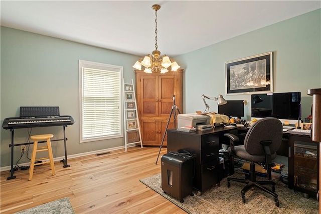 office area featuring wood finished floors, visible vents, baseboards, and a notable chandelier