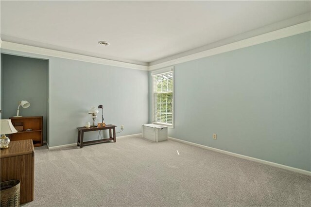 carpeted empty room with visible vents, baseboards, and ornamental molding