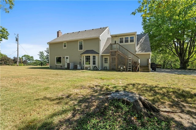 rear view of property featuring a chimney, central AC unit, stairway, and a lawn