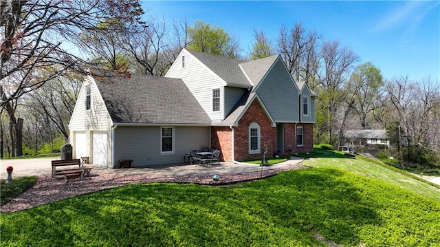 back of property with brick siding, a lawn, a shingled roof, and concrete driveway