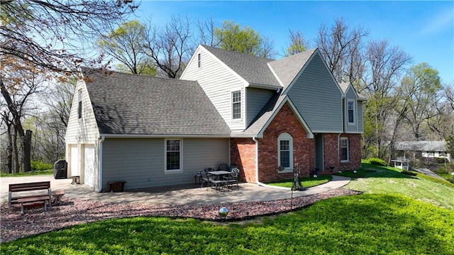 back of property featuring a patio area, a shingled roof, a yard, a garage, and brick siding