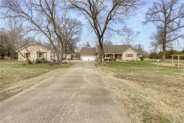 view of front of house with driveway, an attached garage, a chimney, and a front lawn