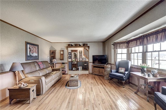 living room with ornamental molding, wood-type flooring, and a textured ceiling